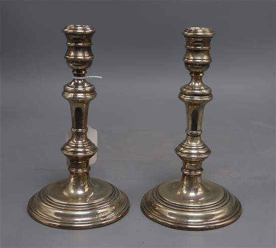 A pair of silver candlesticks of plain baluster form, William Comyns & Sons, London 1975, H 20cm, weighted.